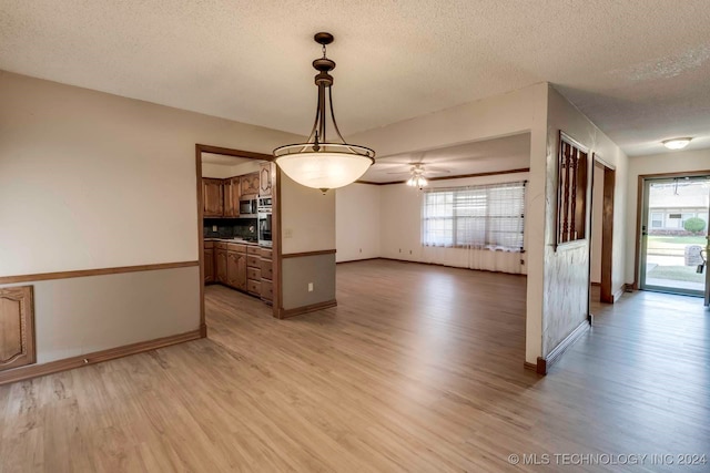 interior space featuring light hardwood / wood-style floors, a textured ceiling, and ceiling fan