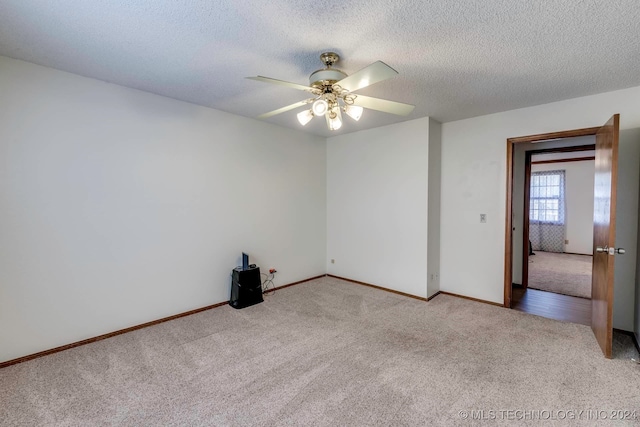 unfurnished room featuring ceiling fan, a textured ceiling, and light carpet