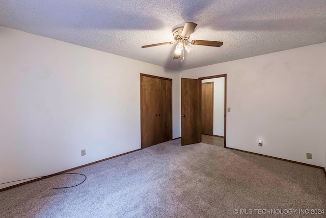 unfurnished bedroom featuring carpet flooring, ceiling fan, and a textured ceiling