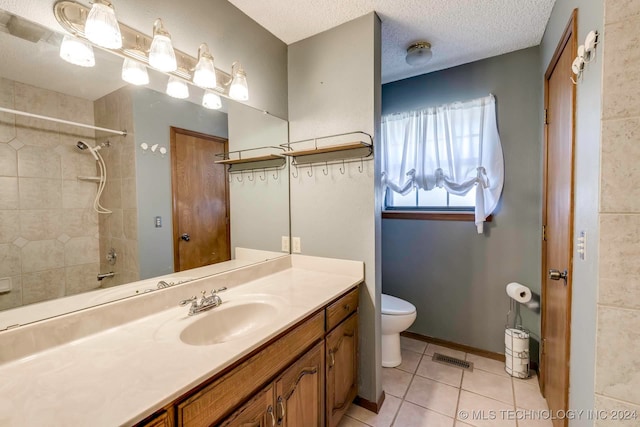 bathroom featuring vanity, tile patterned flooring, toilet, and a textured ceiling