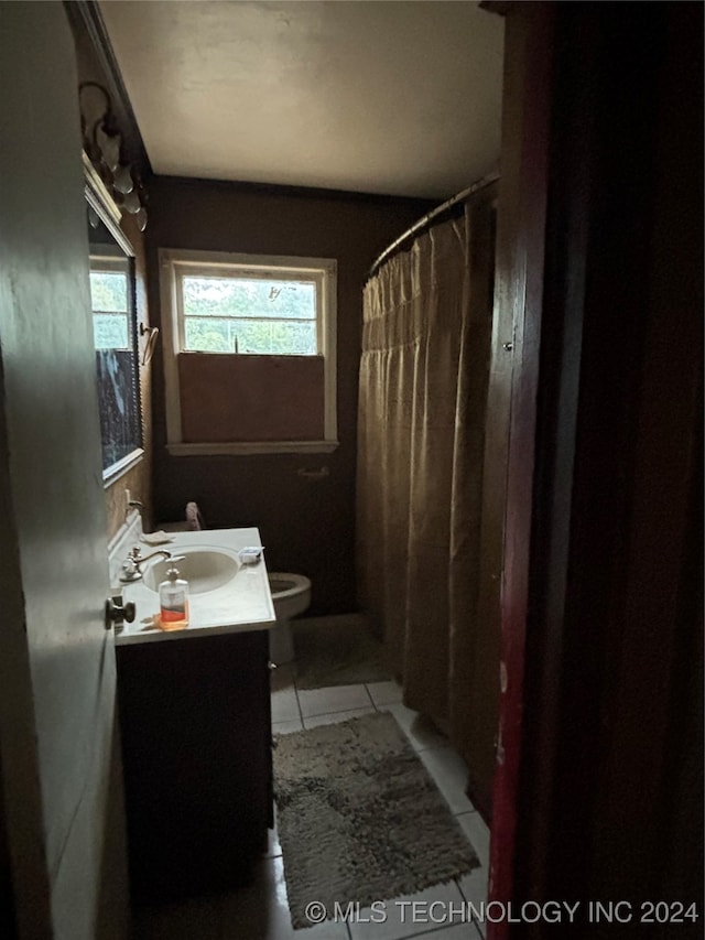 bathroom with tile patterned flooring, a shower with curtain, vanity, and toilet