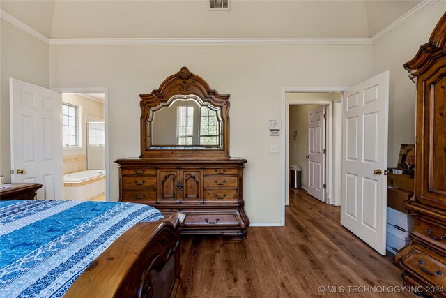 bedroom featuring vaulted ceiling, ornamental molding, ensuite bath, and dark hardwood / wood-style flooring