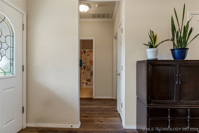 entrance foyer with ornamental molding and dark hardwood / wood-style floors