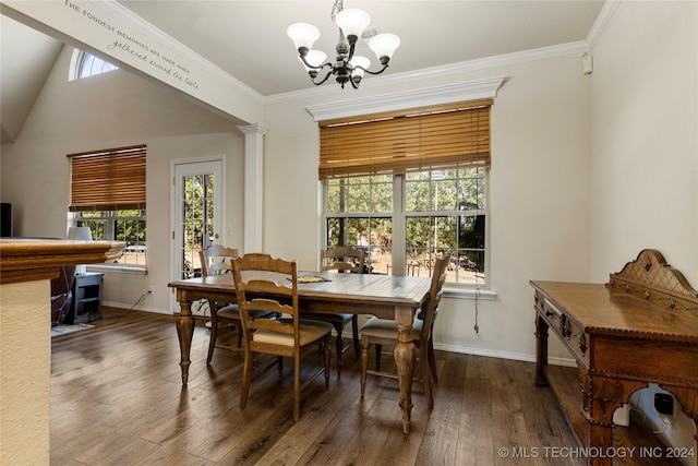 dining space featuring lofted ceiling, wood-type flooring, crown molding, an inviting chandelier, and decorative columns