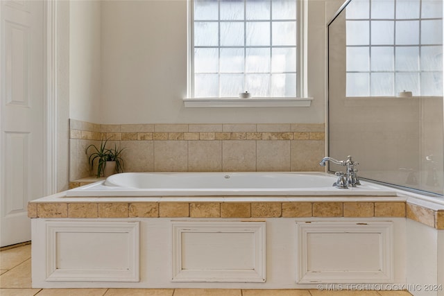 bathroom featuring tiled tub and tile patterned flooring