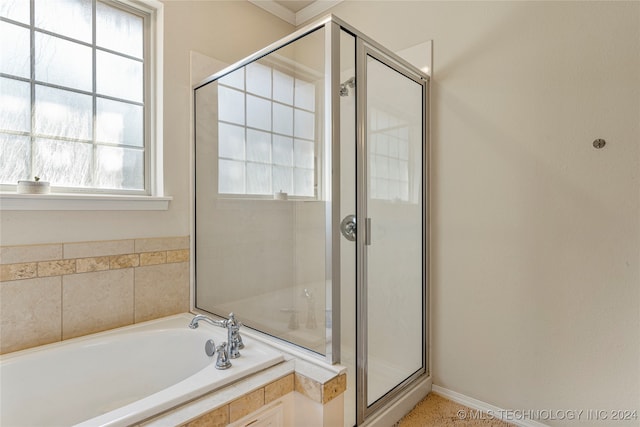 bathroom with shower with separate bathtub and plenty of natural light