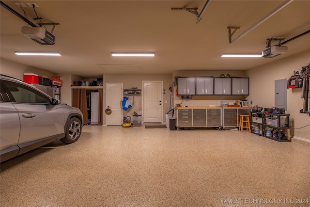 garage featuring electric panel and a garage door opener