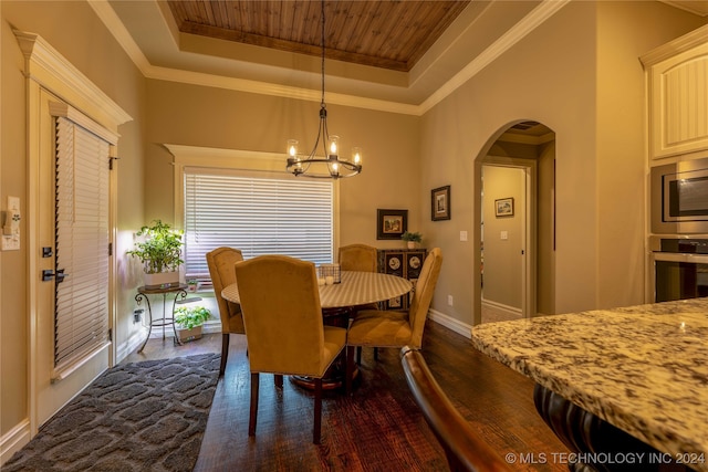 dining room featuring a raised ceiling, a notable chandelier, dark hardwood / wood-style floors, and ornamental molding