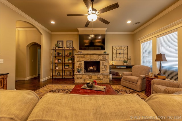 living room featuring ornamental molding, a fireplace, ceiling fan, and dark hardwood / wood-style flooring