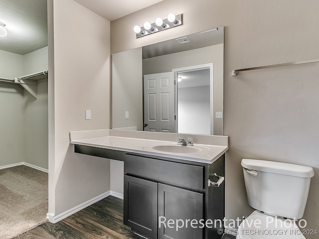 bathroom with hardwood / wood-style flooring, vanity, and toilet