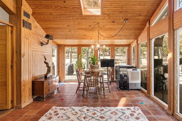 unfurnished sunroom featuring vaulted ceiling with skylight, an inviting chandelier, plenty of natural light, and wood ceiling