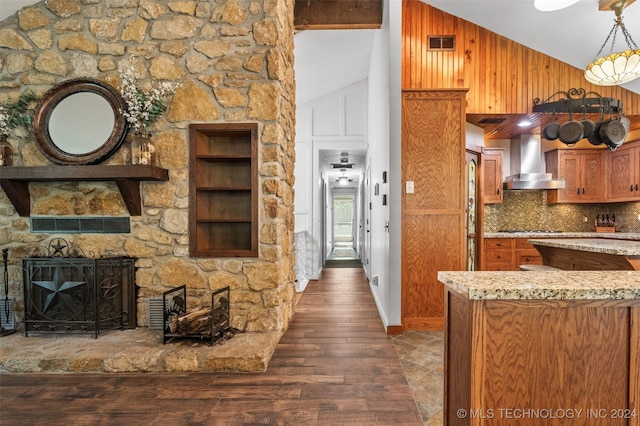 kitchen featuring backsplash, dark hardwood / wood-style flooring, wall chimney exhaust hood, hanging light fixtures, and lofted ceiling