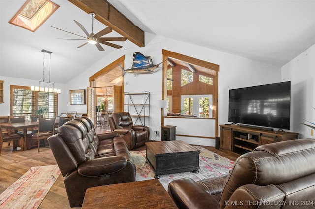 living room with a skylight, ceiling fan with notable chandelier, beam ceiling, high vaulted ceiling, and light hardwood / wood-style floors