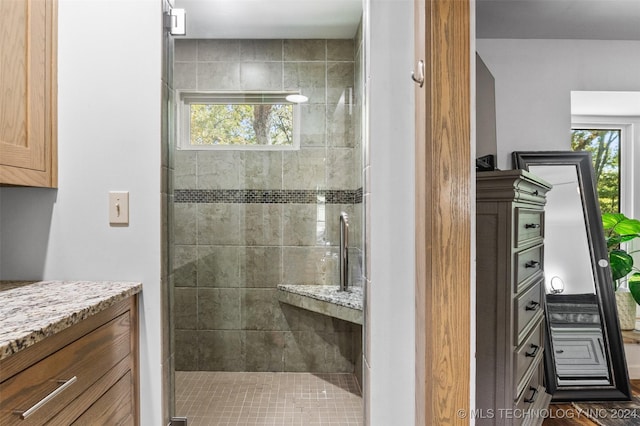 bathroom with vanity and tiled shower