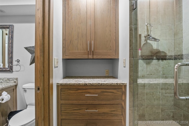 bathroom featuring vanity, toilet, and walk in shower