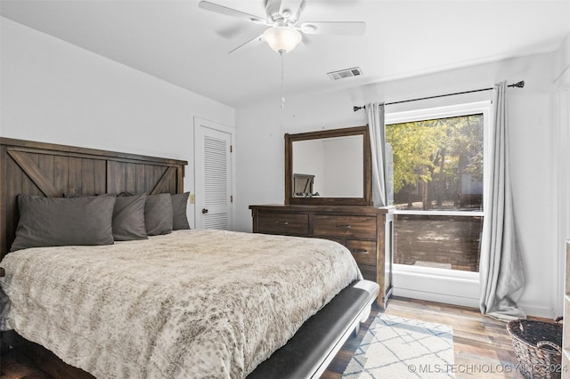 bedroom with hardwood / wood-style floors, a closet, and ceiling fan