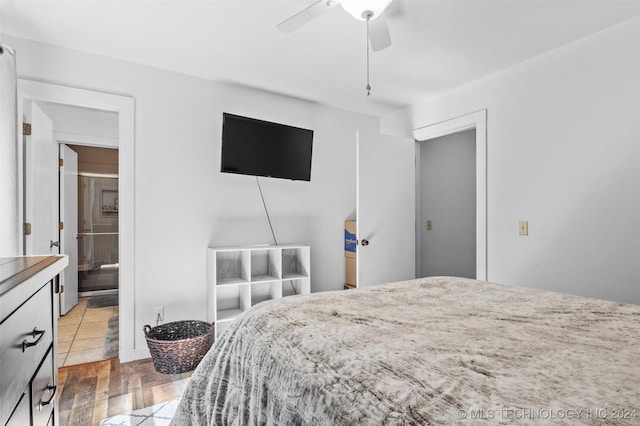 bedroom featuring ensuite bath, ceiling fan, and hardwood / wood-style flooring