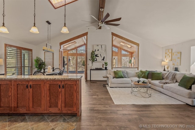 living area with lofted ceiling, dark wood-style floors, a wealth of natural light, and a ceiling fan