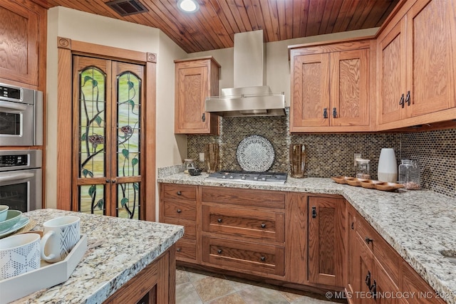 kitchen with wood ceiling, visible vents, wall chimney range hood, tasteful backsplash, and stainless steel gas stovetop