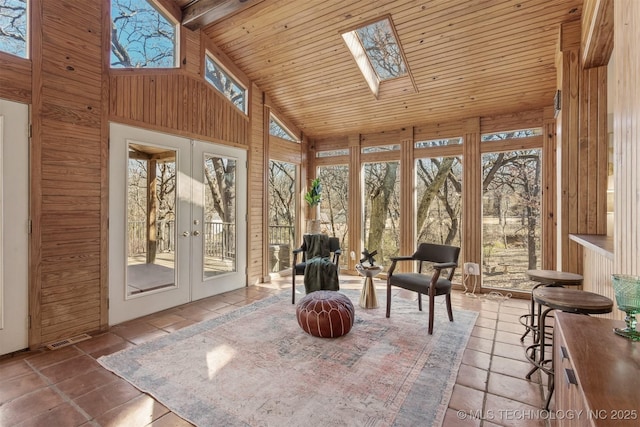 sunroom featuring lofted ceiling with skylight, wooden ceiling, and french doors