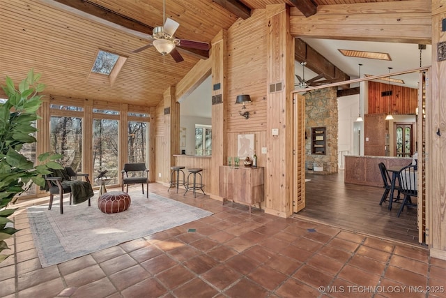 interior space featuring visible vents, lofted ceiling with skylight, wood ceiling, and a ceiling fan