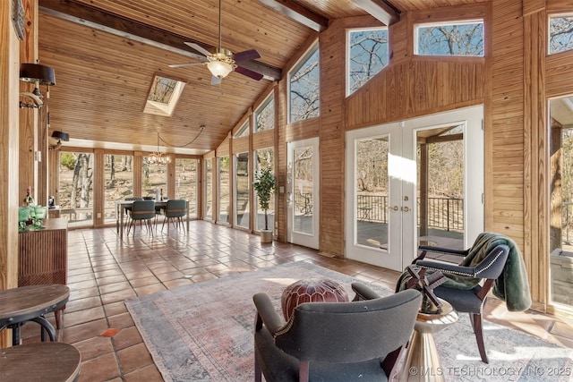 sunroom featuring ceiling fan, vaulted ceiling with skylight, french doors, and wood ceiling