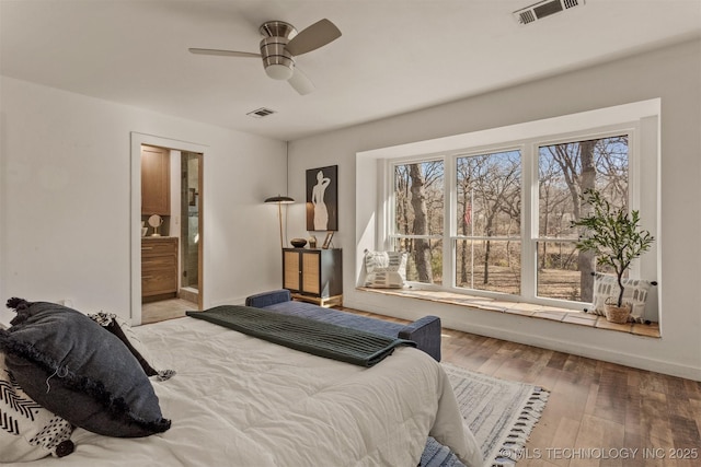 bedroom featuring ensuite bathroom, hardwood / wood-style floors, visible vents, and a ceiling fan