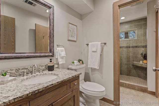 bathroom featuring toilet, a stall shower, visible vents, and vanity