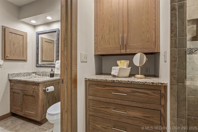 bathroom with toilet, tile patterned flooring, baseboards, and vanity