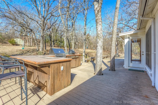 wooden terrace featuring exterior kitchen and area for grilling