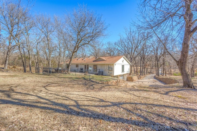 view of front of home featuring central AC and fence