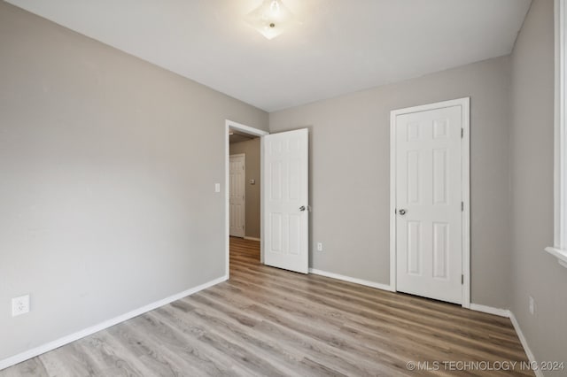 unfurnished bedroom with a closet and light wood-type flooring