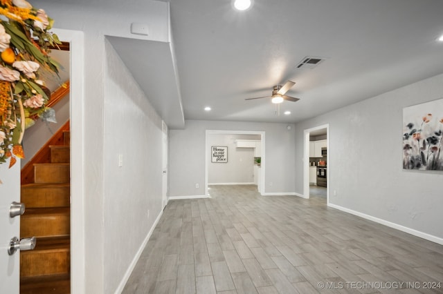 unfurnished living room featuring ceiling fan and light hardwood / wood-style flooring