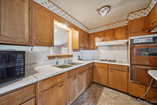 kitchen featuring white gas stovetop, sink, and double oven