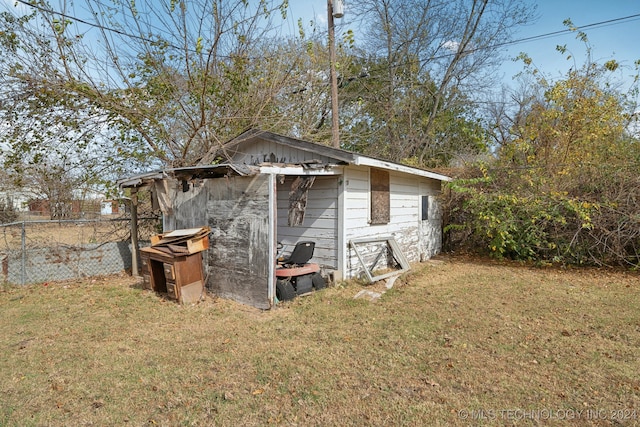 view of home's exterior with a storage unit and a lawn