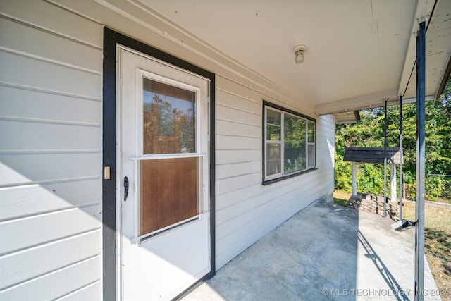 view of exterior entry with a patio area