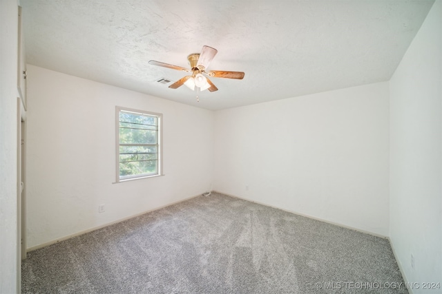 unfurnished room with ceiling fan, a textured ceiling, and carpet flooring