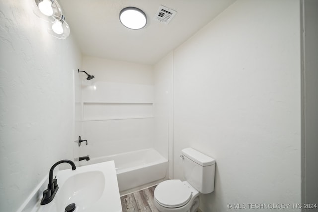 bathroom with wood-type flooring, toilet, and shower / washtub combination