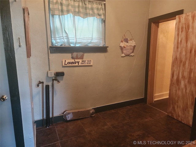 laundry area featuring dark tile patterned flooring