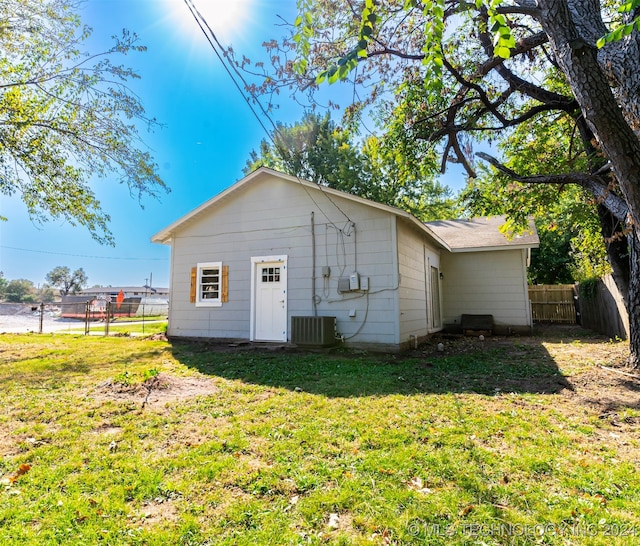 rear view of property with a yard and central AC unit