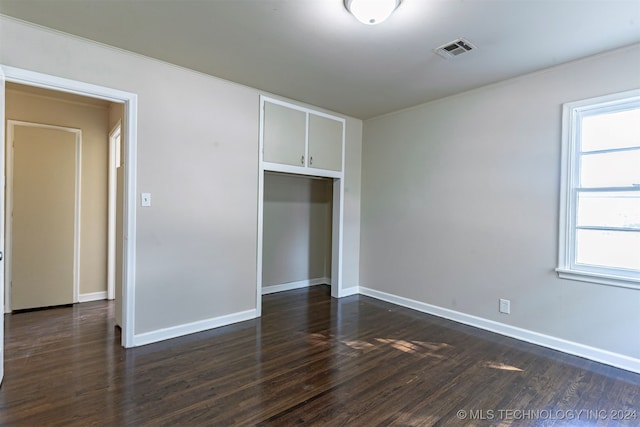 unfurnished bedroom with a closet and dark hardwood / wood-style floors