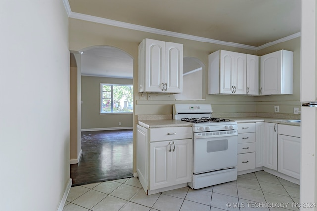 kitchen featuring ornamental molding, light wood-type flooring, white range with gas stovetop, and white cabinets