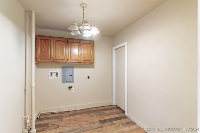 washroom featuring electric panel, cabinets, light wood-type flooring, a notable chandelier, and electric dryer hookup