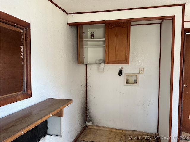 laundry room featuring crown molding, hookup for a washing machine, and cabinets