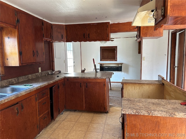 kitchen with a textured ceiling, sink, and kitchen peninsula