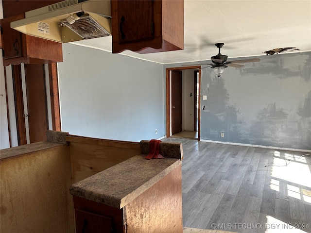 interior space featuring wood-type flooring, range hood, and ceiling fan