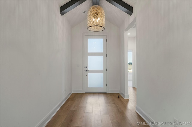 entryway with hardwood / wood-style floors and vaulted ceiling with beams