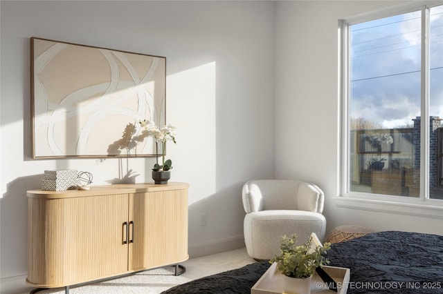 living area with plenty of natural light and light carpet