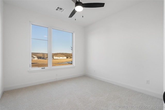 spare room with carpet floors, a wealth of natural light, and ceiling fan