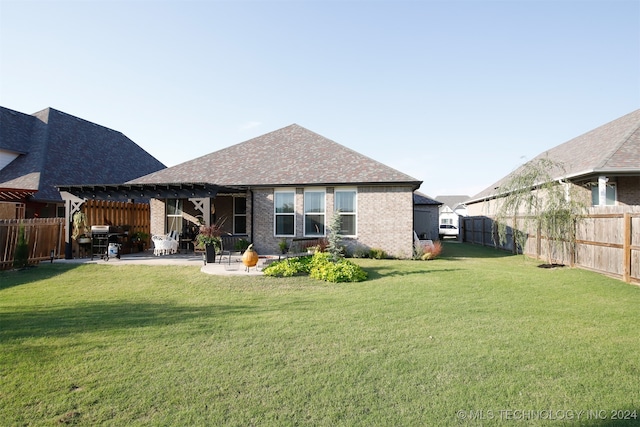 rear view of house featuring a lawn, a pergola, and a patio